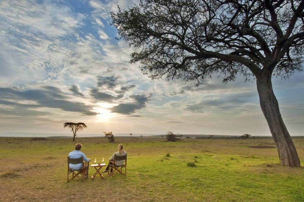 Tourists relaxing while looking into the sunset at Masai Mara National Reserve